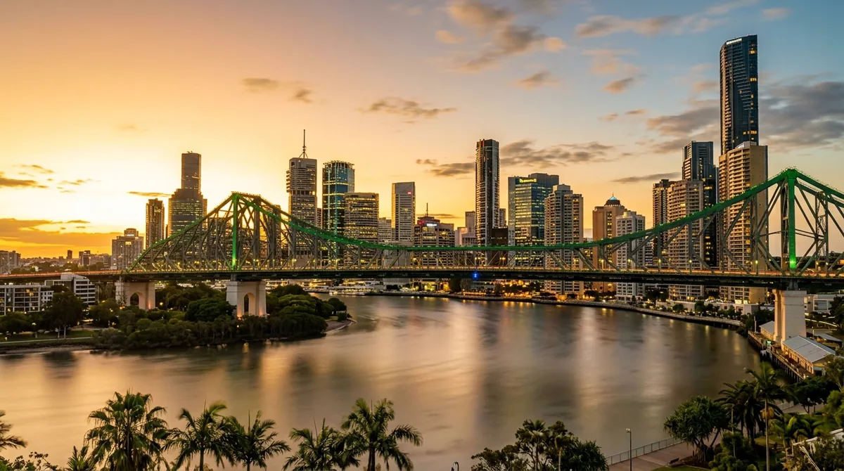A green steel arch bridge over the Brisbane River at golden hour